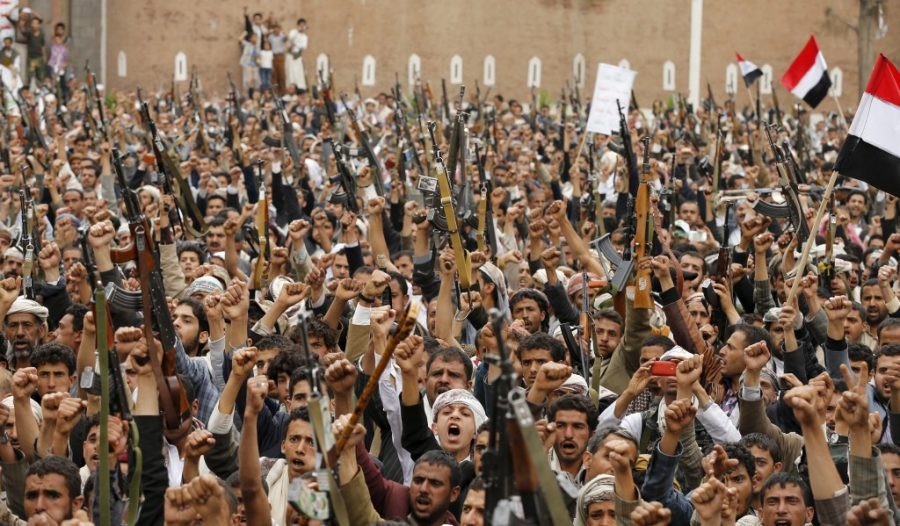 Shiite Muslim rebels hold up their weapons during a rally against air strikes in Sanaa