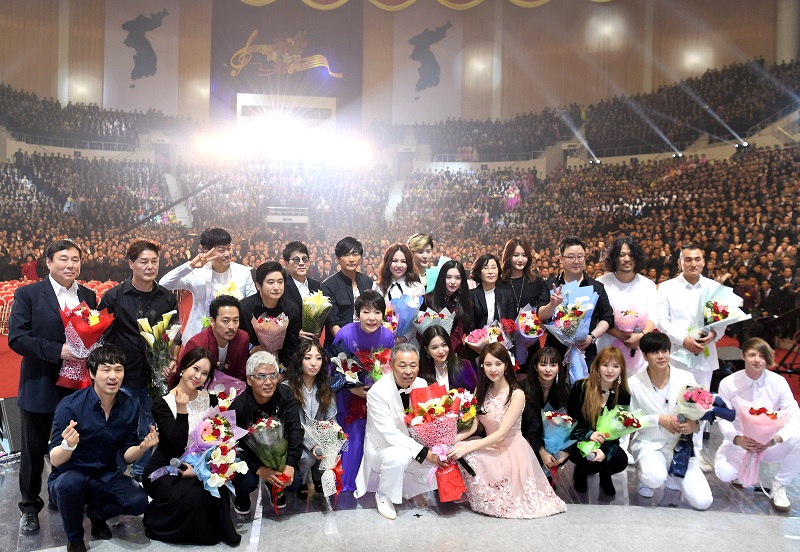 South Korean artists take a group photo, with North Korean people seen in the background, after performing at the Ryugyong Jong Ju Yong Gymnasium in Pyongyang, North Korea April 3, 2018.   Korea Pool/Yonhap via REUTERS ATTENTION EDITORS - THIS IMAGE HAS BEEN SUPPLIED BY A THIRD PARTY. SOUTH KOREA OUT. NO RESALES. NO ARCHIVE.     TPX IMAGES OF THE DAY