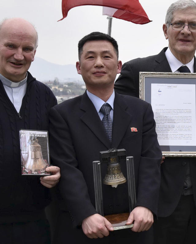 RECROP OF TRV103 - This March 20, 2018 photo made available Thursday, Jan. 3, 2019 by the Parish of Farra di Soligo, shows North Koreas acting ambassador to Italy Jo Song Gil, center, holding a model of Bell of Peace of Rovereto during a cultural event on the occasion of a visit of the North Korean delegation to the Veneto region, in San Pietro di Feletto, near Treviso, northern Italy. Jo Song Gil, went into hiding with his wife in November, South Koreas spy agency told lawmakers in Seoul on Thursday. Jo Song Gil is flanked by don Brunone De Toffol, parish priest of Farra di Soligo, left, and Senator Valentino Perin, right. (Parish of Farra di Soligo via AP)