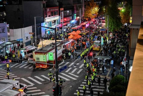 Onlookers, paramedics, and others gather in one of the main roads in Itaewon on October 2022