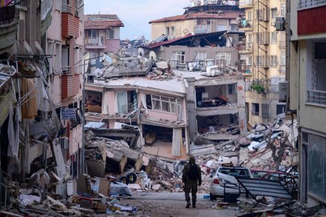 A Turkish soldier on Sunday walks among buildings that were destroyed by the Feb. 6 earthquakes in Hatay, Turkey. | AFP-JIJI