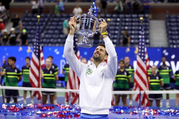 Djokovic holding up the US Open Championship trophy in celebration