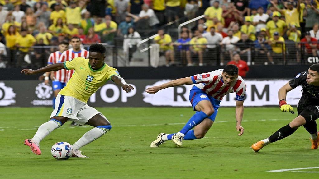 Brazil's Vinicius Junior, left, scores his side's opening goal against Paraguay during a Copa America Group D soccer match in Las Vegas, Friday, June 28, 2024. (AP Photo/David Becker)