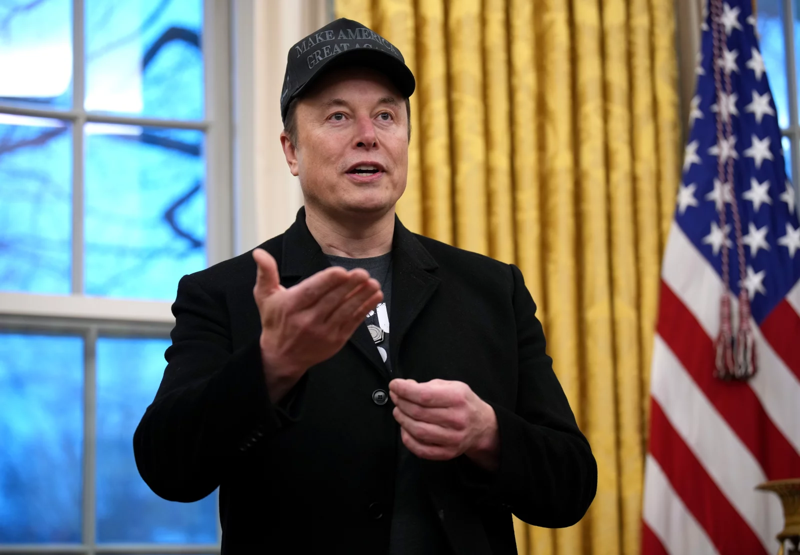 Elon Musk speaks at the Oval office as President Trump signs an executive order limiting the size of the federal workforce