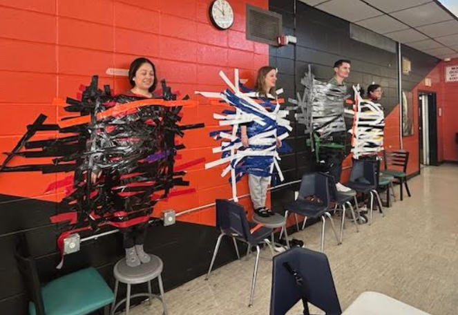 Ms. Urbaez, Ms. Barker, Ms. PM, and Mr. Nyfenger stuck to the wall.
